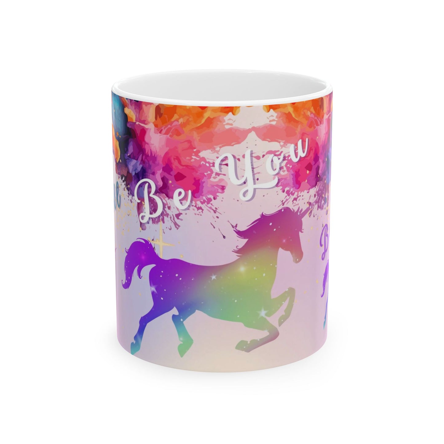 A white ceramic mug featuring a vibrant, colorful watercolor design with a purple unicorn silhouette, the words 'Be You' in white script, and a rainbow gradient background.
